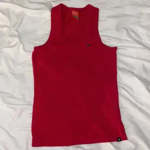 Cerise/rödfärgat sportlinne från Nike. Storlek M