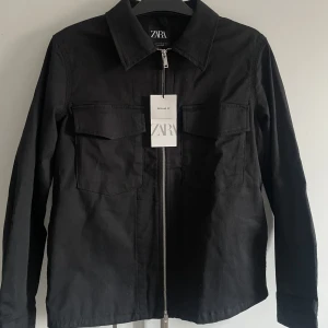 Svart overshirt  - Svart overshirt från zara i storlek S. Aldrig använd, fick den i present och hann inte lämna tillbaka den. Köparen står för frakten.
