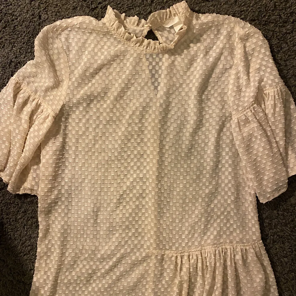 Benvit blus med volanger från H&M. I superbra skick, men används ej av mig längre. . Puserot.
