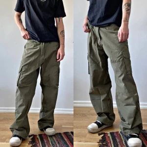 Gröna khaki baggybyxor cargobyxor - Ett par feta baggy cargobyxor i khaki färg. Använt ett par gånger annars i fint skick, förutom ena knapp grejen nere i byxan på höger ben. Har tejpat ihop den lol. Märket är TownzBrand! Mått; midja 37 cm, längd 102 cm varav innerbenslängden är 72 cm.