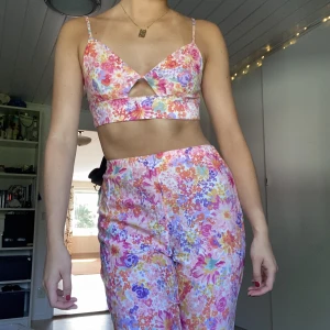 Blommigt set  - Blommigt set från Hm. Använd 1 gång. Toppen har resår i bak, se bild 3, skulle därför säga att den passar fler än stl s.  Jag är 175 cm