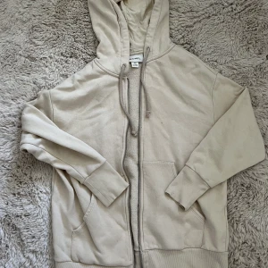 Beige zip up hoodie från monki - Beige oversized zip up hoodie i storlek xxs. Bara använd några få gånger och i jätte bra skick.