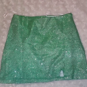 PRISLAPP KVAR glittrig kjol med slits - Köpt på Nelly. PRISLAPP KVAR! Önskar att kameran kunde fånga hur fint den glittrar🥰Påminner om Taylor Swifts 1989-kjol om någon behöver kläder till Eras Tour ;) Säljer då jag köpte 2 storlekar. Man kan lätt vika in den om man vill ha lägre midja.