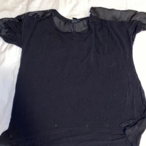 T-shirt - Säljer en svart T-shirt, vid axlarna har den som siden tyg.  Är från H&M och är i storlek M. OBS: köparen står för frakten. (Annonsen finns ute på fler sidor)
