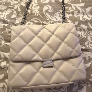 Beige Axel väska - Säljer nu min fina beiga kedjeväska! Använd 1 gång då jag redan har en i annan färg!🌸Så så fin! Säljer för 100kr