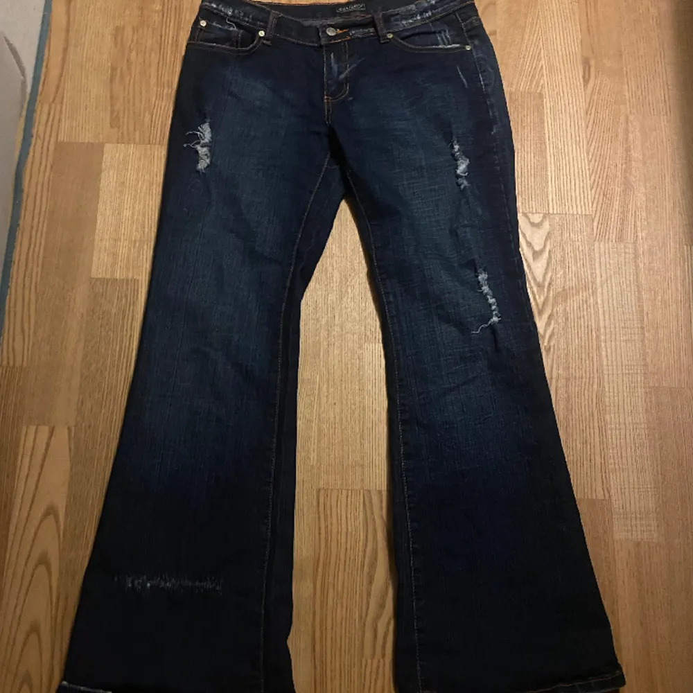 jätte snygga lågmidjade jeans med print på fickorna och lite slitningar. köpt secondhand men med lite användning. långa på mig, är 158. pris går att diskutera!. Jeans & Byxor.