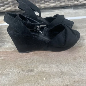 Klackarskor  - Ett par svarta klackaskor som är använda en gång. 