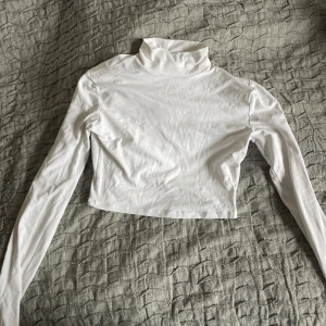 Crop top med polokrage  - Vit tajt crop top med polokrage från bershka. Jättebra skick knappt använd. Skicka gärna för frågor.