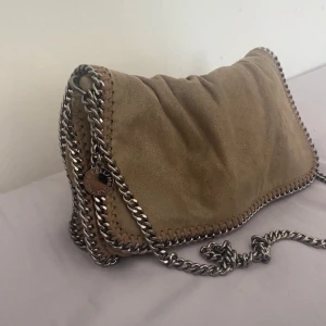 Stella McCartney väska - Superfin brun/beige Stella McCartney väska i helt okej skick. Materialet är slitet men fortfarande as fin😍