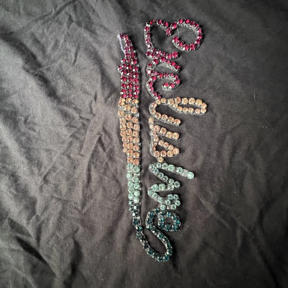 Mörkgrå t-shirt från zara med texten ”exklusive” på skriven i färgglada pärlor.. T-shirts.