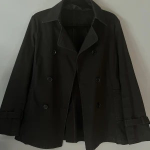 Svart höstjacka - Snygg jacka perfekt till höst/vår. Lappen är bortklippt så ser inte storlek eller märke. Uppskattas till en S/M. Bra kvalitet. Fina detaljer på jackan. Finns tillhörande band/skärp🖤🖤🖤obs! Sista bilden ser jackan fläckig ut, det är spegeln😅