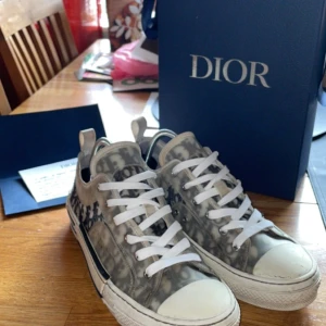 Dior b23 low - Säljer nu mina dior b23 low. Dom är i använt skick men inga hål eller skador på dom. Självklart äkta, köpta på diors hemsida för ca 10 000 nypris! Var inte rädda att höra av er vid intresse eller frågor. 