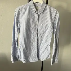 Blå och vit skjorta, använd 3 gånger. Är i fint skick, man kan även rulla upp armarna. Skickar gärna fler bilder om du vill, frakten tillkommer 💫