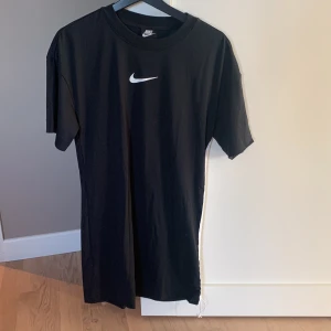T-shirt klänning från Nike  - T-shirt klänning från Nike. Sparsamt använd, fint skick! Storlek XS. Med dragsko på sidan av klänningen.  Nypris 499:-