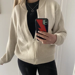 Stickad kofta med dragkedja  - Fin ljus beige stickad kofta med dragkedja! 