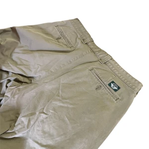Dockers byxor - Ett par mörk beiga Dockers byxor i fint skick. Använda fåtal gånger, har dock bleknade stänk fläckar i nederkant på båda benen, syns ej på långt håll. Innerbenslängd: 75cm. Midjemått: 90cm. Benbredd lår: 31cm. Benbredd smalben: 24cm. 