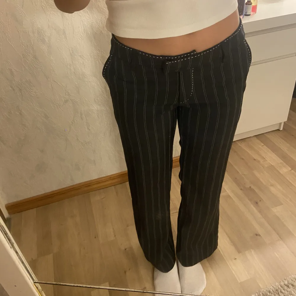 Säljer svarta lågmidjade kosytmbyxor med vita detaljer från Vero Moda🤩. Jeans & Byxor.