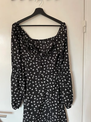 Klänning  - Klänning med dragkedja i sidan och snöre som knyts vid bröstet.