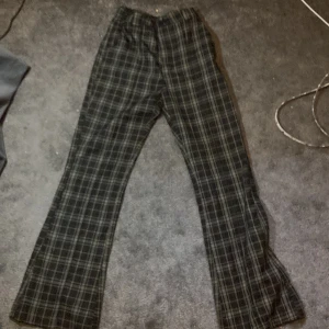 Flared byxor - Mörka flared rutiga byxor.Fint skick. Använt fem gånger