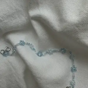 Detta är ett handgjort armband i pärlor av blåa nyanser. Det har ett silverfärgat spänne och är 17 cm långt. (Specialbeställning av färg och länd kan även ske)