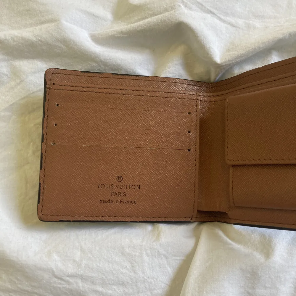 Louise Vuitton plånbok med två stora fack för sedlar, 3 fack för kort, ett till fack bakom korten och ett fack för mynt som har en knapp där man kan stänga. . Övrigt.