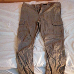 Bruna/beiga byxor från H&M - Det är ett par byxor från H&M i kill storleken 38/185/96A. Passar mig fortfarande men är inte min stil. De har fickor både fram och bak.