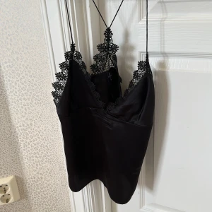 Svart sidenlinne - Svart sidenlinne med spetsfetaljer från Massimo Dutti studios