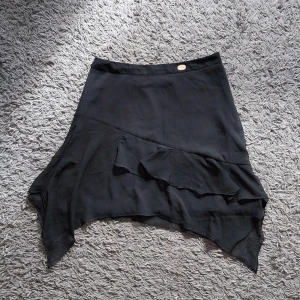 Svart kjol - Svart kort kjol från Chiara Forthi med lite volanger. i storlek S . Oanvänd.   Betalning sker via swish och köparen står för frakten.  