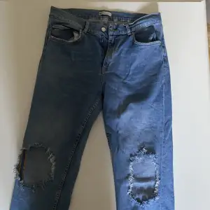 Blåa jeans från ginatricot i storlek 42 med hål i knäna. Passar tyvärr inte mig längre 