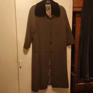 Skön och varm vinterkappa. - Har en rejäl och fin vinterkappa av märket MasterCoat worldwide. Perfekt för kalla vinterdagar, dessutom så är den ju så snygg också.  Kragen är fuskpäls och 2 knappar har ramlat loss (se bild) men superenkelt att själv sätta dit.  Som ny!