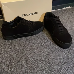 Axel arigato skor - Ett par Axel arigato skor i storlek 43 nytt skick använda 3 gånger, det ingår en Axel arigato väska,  stickers nytt skick på Axel arigato väskan.