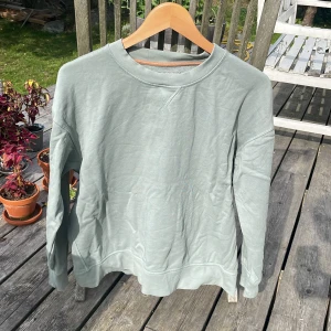 Mjuk grön tjocktröja - Mjuk tjocktröja från COS. Sparsamt använd. Används då jag inte har fått anvpndning för den på ett tag. Gott skick annars. Passar snyggt med jeans. Bomull