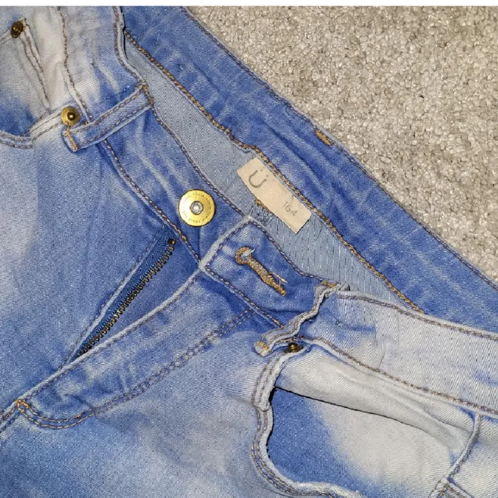 Blåa håliga jeans från KappAhl. Det står storlek 164, men skulle säga att den passar XS-S. Knappt använd, så i jättebra skick! Kan fraktas, men köparen står för frakten 🥰. Jeans & Byxor.