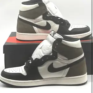 Jordan 1 Dark Mocha Finns att köpa på hemsidan https://citysneakers.company.site/   Hej där! Jag säljer ett par Jordan 1 Dark Mocha sneakers i utmärkt skick. Dessa sneakers är en äkta pärla för sneaker-entusiaster och kommer verkligen att sätta stilen.  