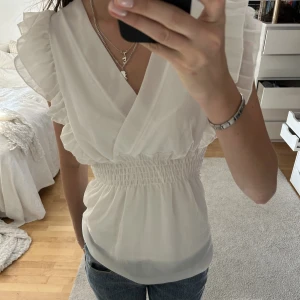 Vit blus med volanger - Assöt vit blus med volanger!
