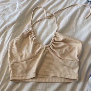Beige topp - Beige topp ifrån SHEIN som man knyter i nacken. Helt oanvänd!