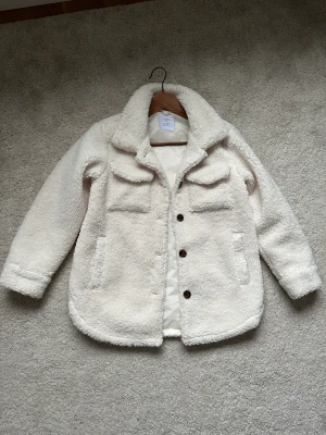 Jacka från Lindex  - Vit flufig overshirt perfekt som höstjacka. Använd  en säsong och i superfint skick, hel och ren.   Storlek 146-152 (10-12 år)  Inköpt för 499kr