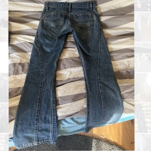 Lågmidjade jeans - Svinsnygga lågmidjade bootcut jeans med coola detaljer på baksidan!  Säljer på grund av att dom tyvärr inte passar längre. Jag är 166cm och längden är bra på mig, lite oklart vad jeansen har för storlek men skulle säga 32/34