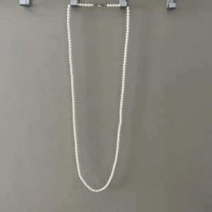 Pärlhalsband - Långt pärlhalsband. Man kan göra så att det ser ut som att man har två halsband på sig.