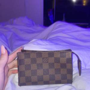 En helt ny och äkta mini necessär från Louis Vuitton.  Köpt tillsammans med en större nessecär så därför vet jag inte vad just den kostar nypris. 