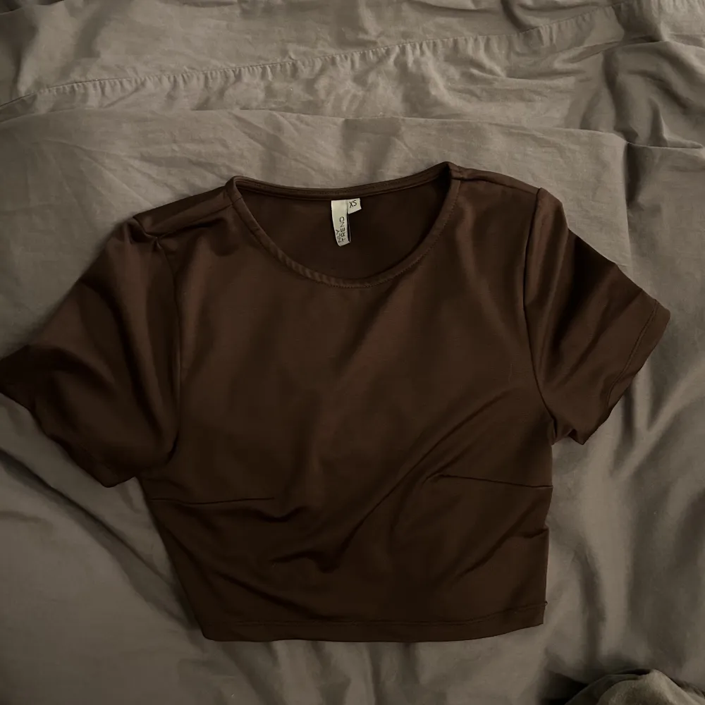 Croppad brun t-shirt från nelly. Storlek xs. T-shirts.