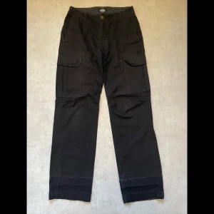 Dickies cargo pants - Dickies cargo pants i storlek 31/34. Jag har kavlat upp dom vid användning för dom var för långa för mig. Detta har gjort att det har gått hål i vecket (sista bilden). Annars är skicket okej.