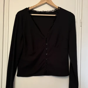 Svart topp med knäppning  - Gullig svart topp med knäppning, säljer på grund av att den inte passar så bra på en större byst.  Kan mötas upp inom stockholm eller skicka mot frakt!✨