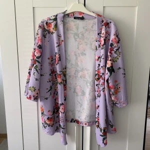 Blommig kimono - Jättefin kimono köpt på Boohoo i storlek L! Har inte använt den mycket, den är i jättefint skick. Väldigt bra kvalité. Säljer då jag inte har använt den på länge. 