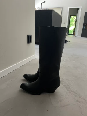 Cowboyboots från zara  - Säljer dessa helt nya cowboyboots med lapp kvar. Köptes för 699 men har aldrig använts. I svart skinnimitaion. Perfekta nu till sommaren med klänning😍😍
