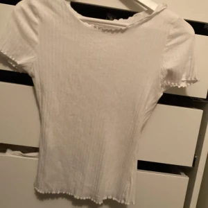Vit T-shirt  - En vit fin T-shirt, ganska basis plagg som går med det mesta. Aldrig använd, lite ribbad.