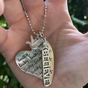 Halsband - Fint smycke från Cecil. Har en pärla i nacken som fungerar som tyngd så att inte låset åker fram. På hjärtat står det lucky om och om igen.  