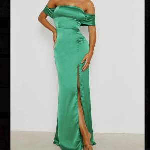 En vacker satin långklänning med off shoulder och slits längst benet i emerald färg! Bara använd en gång❣️   Nypris: cirka 720kr