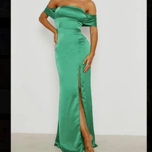 Långklänning  - En vacker satin långklänning med off shoulder och slits längst benet i emerald färg! Bara använd en gång❣️   Nypris: cirka 720kr