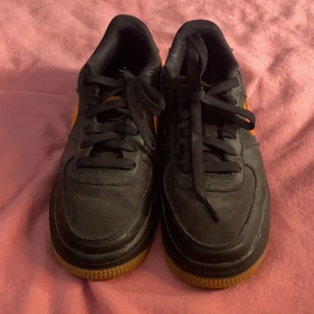 Säljer dessa Nike Air Force i svart och orange, dom är nästan aldrig använda💓. Skor.